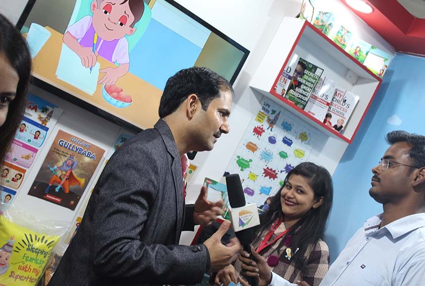 A young reader receiving a GullyBaba Kids book at the fair